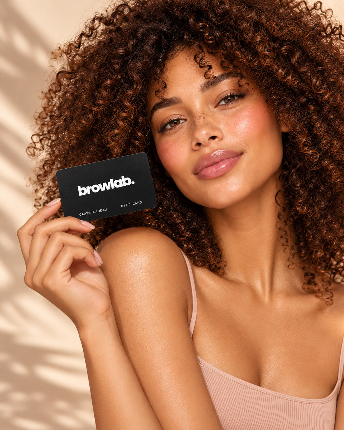 E-carte cadeau Browlab noire posée sur une pierre beige